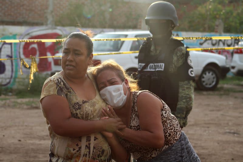 Women react outside a drug rehabilitation facility where assailants killed several people, according to Guanajuato state police, in Irapuato