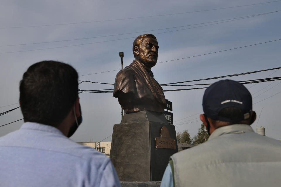 Hezbollah supporters look at a statue of Iranian General Qassem Soleimani, head of Iran's Quds force, installed to commemorate the anniversary of his killing, in a U.S. drone strike in Baghdad, in Ghobeiry, a southern suburb of Beirut, Lebanon, Wednesday, Jan. 6, 2021. (AP Photo/Bilal Hussein)