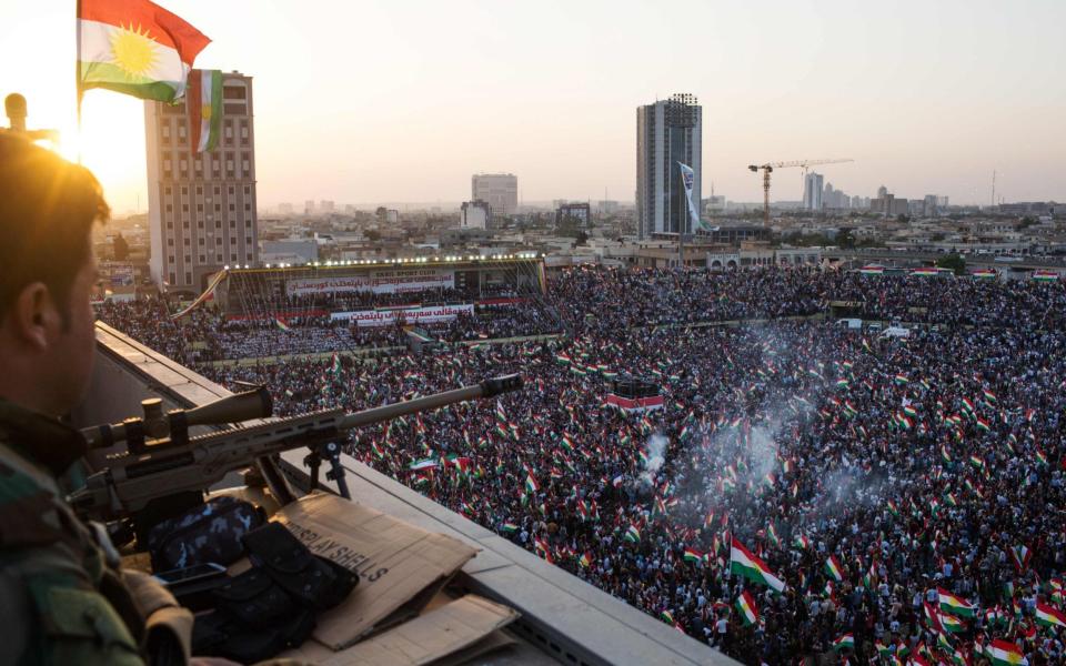 A peshmerga fighter stands watch on a roof as the Iraqi Kurdish leader (unseen) addresses the crowd during a rally to urge people to vote in the upcoming independence referendum in Arbil, the capital of the autonomous Kurdish region of northern Iraq, on September 22, 2017. Iraqi Kurdish leader Massud Barzani insisted that a controversial September 25 independence referendum for his autonomous Kurdish region in northern Iraq will go ahead, even as last-minute negotiations aimed to change his mind. / AFP PHOTO / Mauricio MORALESMAURICIO MORALES/AFP/Getty Images - MAURICIO MORALES/AFP