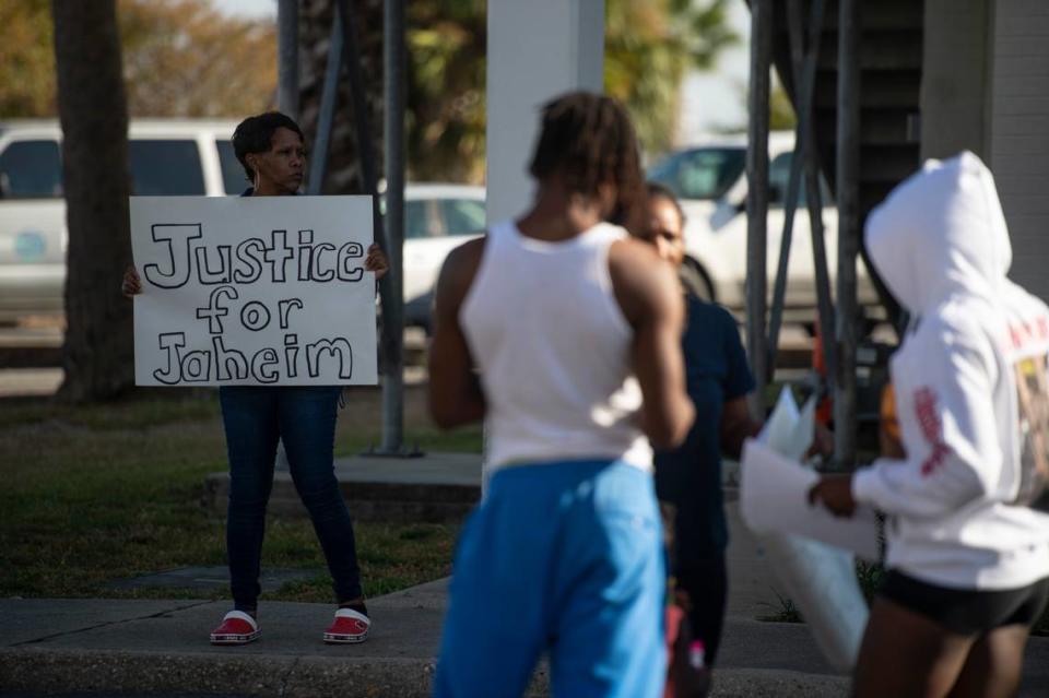 Protesters hold signs in support of justice for Jaheim McMillan, who was shot by police, during a protest outside the Gulfport Police Station in Gulfport on Tuesday, Oct. 11, 2022.