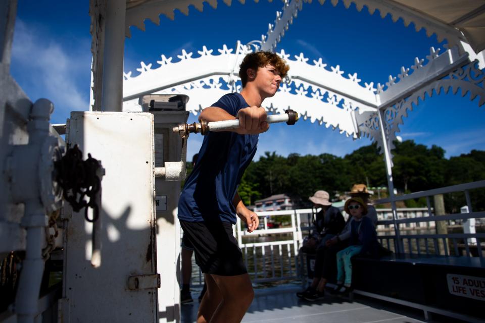 First-year ferry worker Keaton Meeuwsen cranks the gear box that pulls the ferry across the river Friday, Aug. 12, 2022, in downtown Saugatuck.