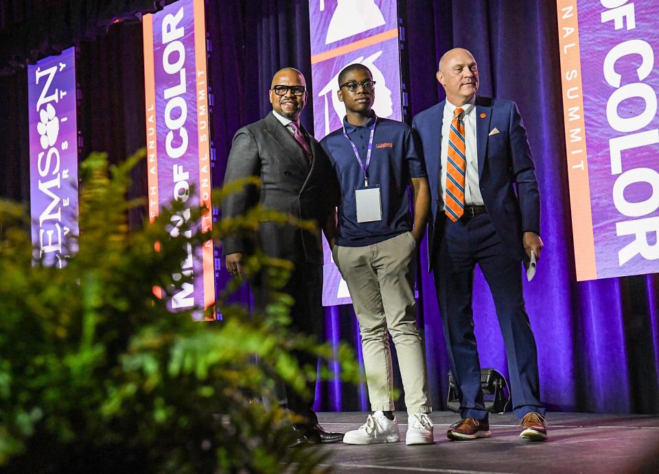 Slevensky Jules, middle, of Carolina High School Tiger Alliance, with keynote speaker Ted Colbert of Boeing, and President Jim Clements, after he was surprised with a $50,000 scholarship from Boeing  during the Clemson University Men of Color National Summit at the Greenville Convention Center in Greenville, S.C. Thursday, April 20, 2022.  