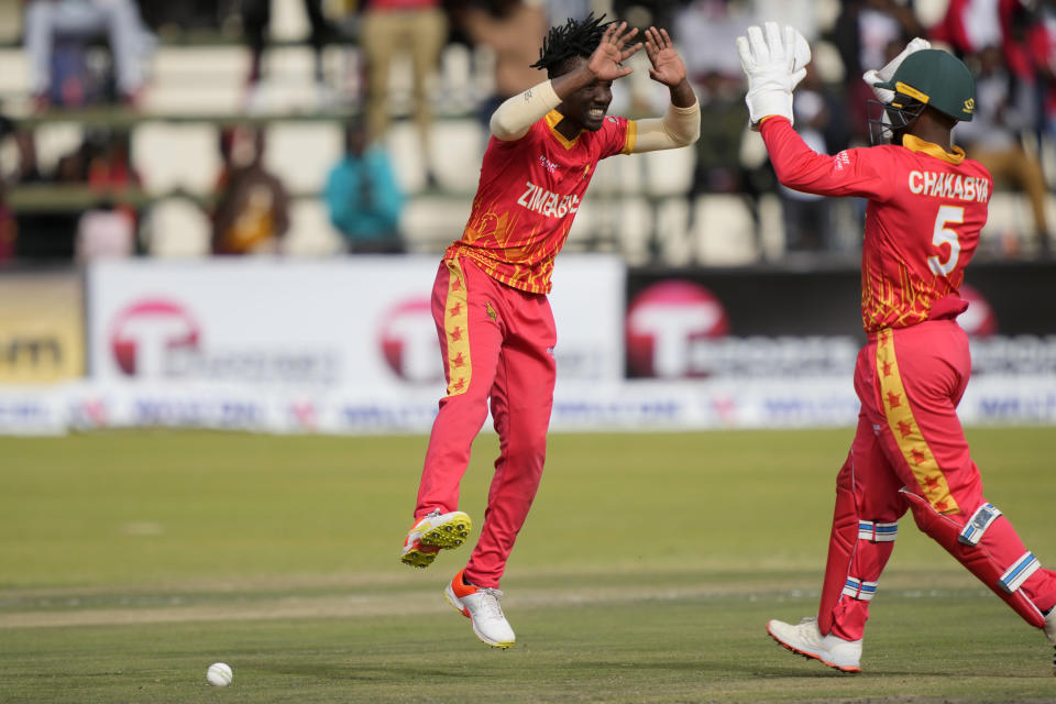 Zimbabwean's bowler Wessly Madhevere, left, celebrates after taking the wicket of Bangladesh's batsman on the final day of the T20 match between Zimbabwe and Bangladesh at Harare Sports Club in Harare, Zimbabwe, Tuesday, Aug. 2, 2022. (AP Photo/Tsvangirayi Mukwazhi)