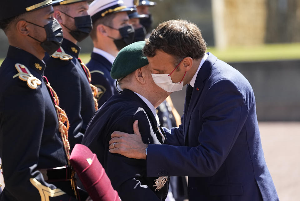 WWII French veterans Leon Gautier, 98 years old last survivor of the Kieffer Commando, left, is honored by French President Emmanuel Macron with the Legion of Honor during a WWII ceremony to mark the 81st anniversary of late French Gen. Charles de Gaulle's resistance call from London on June 18, 1940, at the Mont Valerien, in Suresnes, near Paris, Friday, June 18, 2021. The appeal, which was delivered on the BBC by Charles de Gaulle, served to rally his countrymen after the fall of France to Nazi Germany. (AP Photo/Michel Euler, Pool)