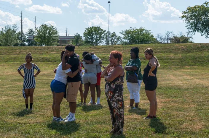 Jon Michael Rone Jr’s family embrace each other in a field near Liquor Land on Tuesday, July 4, 2023, in Kansas City. Rone was the victim of a fatal stabbing that occurred inside of Liquor Land on the 14300 block of E US 40 Highway.