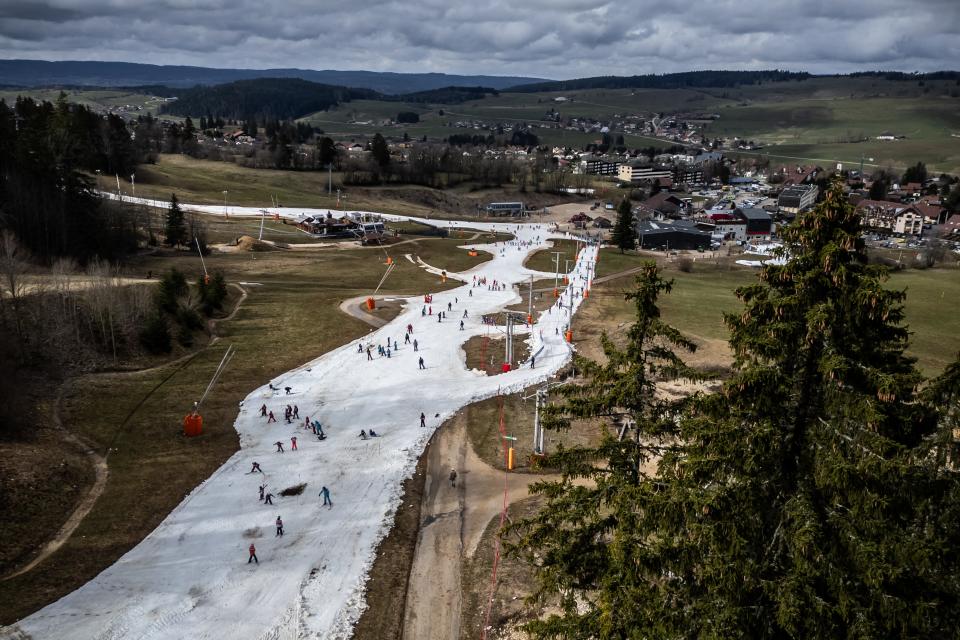 An aerial photograph taken on February 20, 2024, shows ski slopes in a snowless landscape at a ski resort in France. A new study released in March 2024 said that climate change is significantly altering the patterns of natural snowfall worldwide.