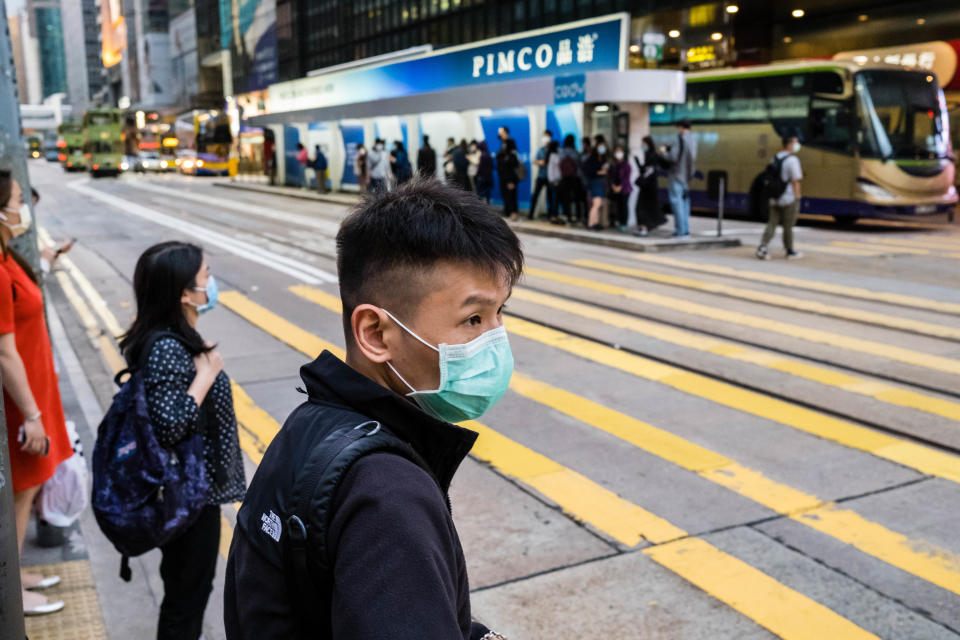 HONG KONG, CHINA - 2020/03/24: A masked man as a preventive measure crossing the street during the corona virus pandemic. As the coronavirus outbreak worsens, routine continues for businessmen and residents around the city, people wear face masks in fear of contracting the virus. (Photo by Willie Siau/SOPA Images/LightRocket via Getty Images)