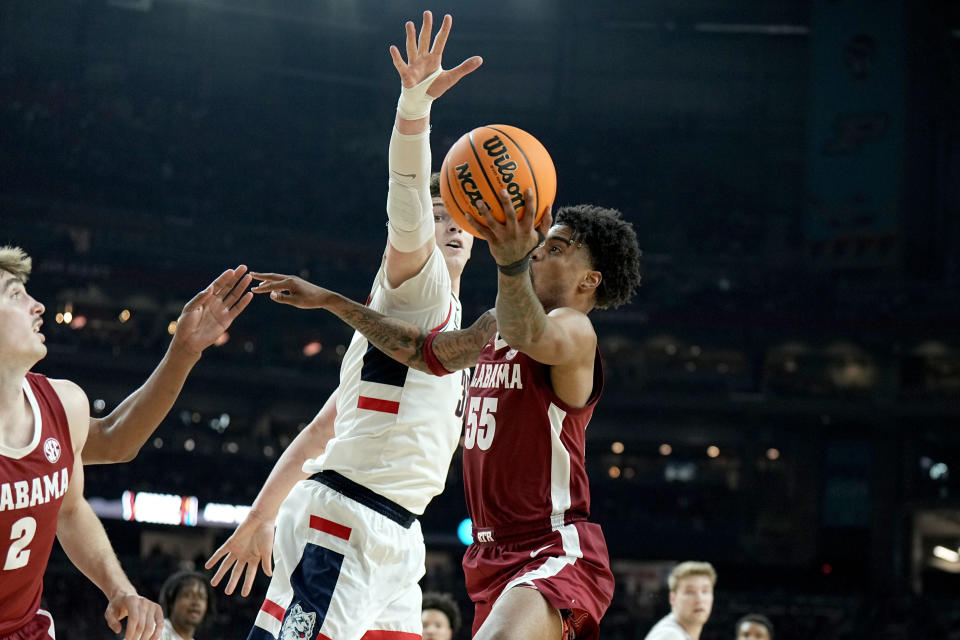 Alabama guard Aaron Estrada, right, shoots around UConn center Donovan Clingan during the second half of the NCAA college basketball game at the Final Four, Saturday, April 6, 2024, in Glendale, Ariz. (AP Photo/Brynn Anderson )