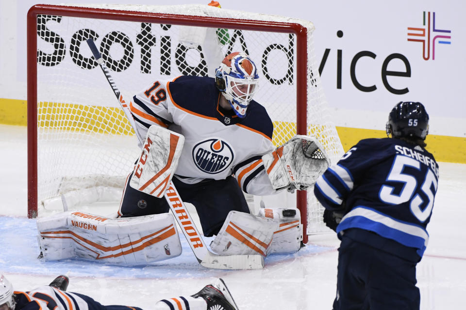 Edmonton Oilers goaltender Mikko Koskinen (19) makes a save on Winnipeg Jets' Mark Scheifele (55) during the second period of an NHL hockey game Tuesday, Jan. 26, 2021, in Winnipeg, Manitoba. (Fred Greenslade/The Canadian Press via AP)