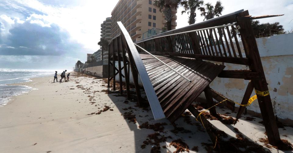 Beachgoers survey the ocean at Van Avenue in Daytona Beach Shores in November 2022, after Tropical Storm Ian damaged a dune walkover. The time to start hurricane preparation is well ahead of a storm's approach, according to the National Hurricane Center and others.