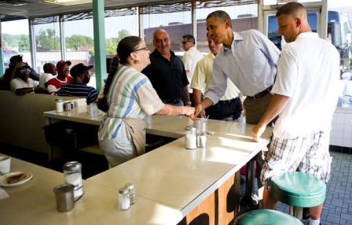 US President Barack Obama shakes hands with a waitress as he arrives at Ann's Place in Akron, Ohio, during an unannounced visit while on a bus tour of Ohio and Pennslyvania