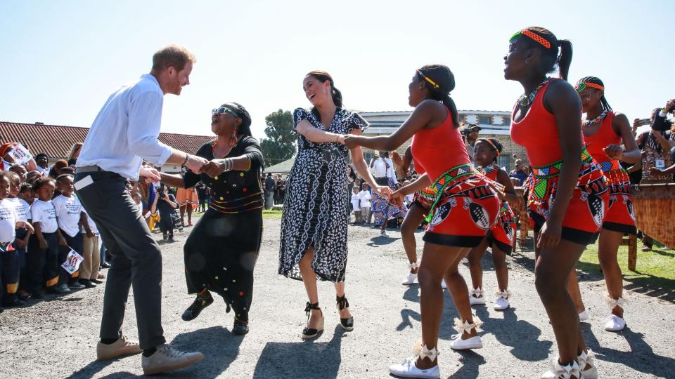 <p> Anyone who's ever felt pressured to partake in an activity at work will relate to this expression of smiling through the pain. </p> <p> While Harry appears to have jumped right in, dancing away with people in the township of Nyanga in Cape Town during their 2019 tour of the region, Meghan perhaps needed a bit more cajoling. </p> <p> A true professional, she got stuck in anyway. </p>