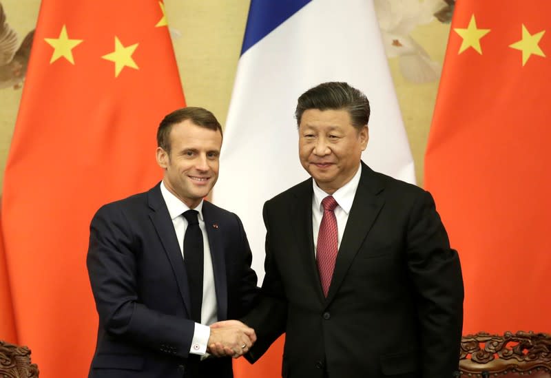 French President Emmanuel Macron shakes hands with China's President Xi Jinping after a joint news conference in Beijing