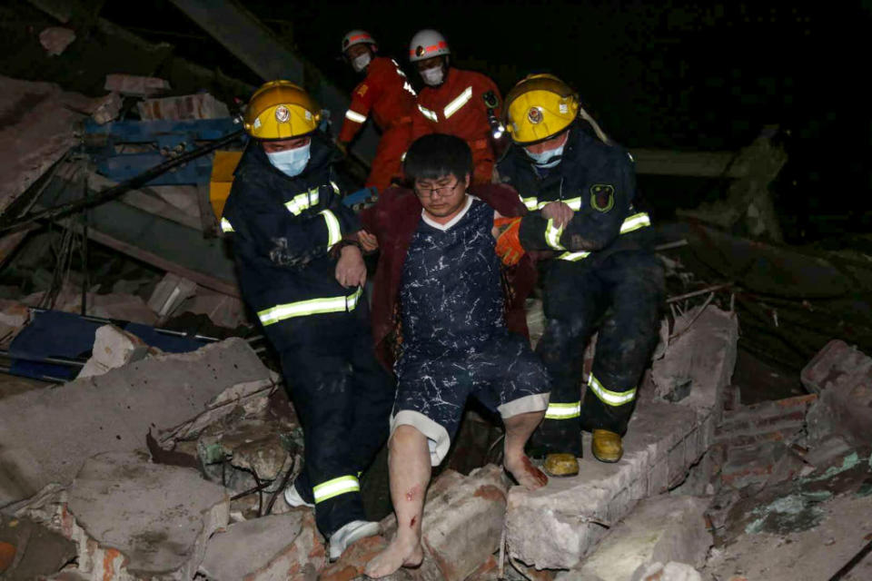 A man is helped out of the rubble by rescue workers. Source: Getty