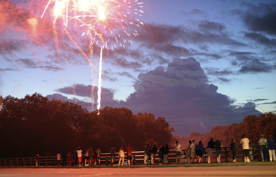 <p>Large clouds linger over the Neuse River as spectators watch fireworks from the George Green Harper Bridge in Kinston, N.C. (Photo: Janet S. Carter/Daily Free Press via AP) </p>