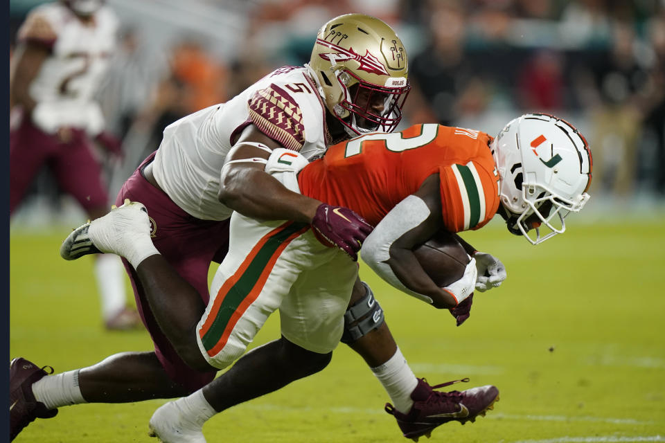 Florida State defensive lineman Jared Verse (5) tackles Miami wide receiver Brashard Smith (12) during the first half of an NCAA college football game, Saturday, Nov. 5, 2022, in Miami Gardens, Fla.(AP Photo/Lynne Sladky)