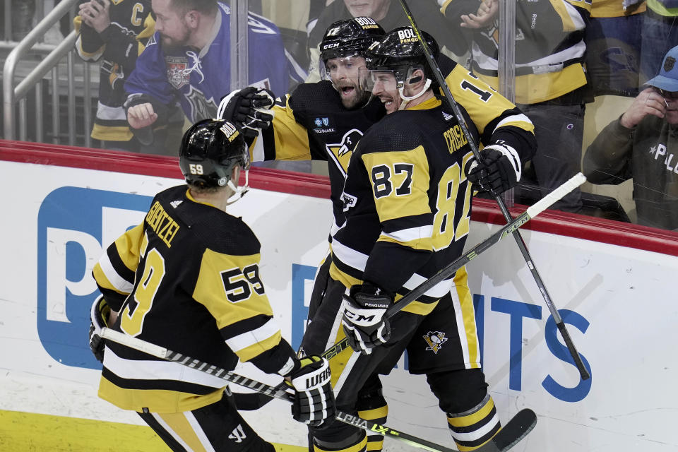 Pittsburgh Penguins' Bryan Rust celebrates with Sidney Crosby (87) and Jake Guentzel (59) after scoring during the second period of an NHL hockey game against the Philadelphia Flyers in Pittsburgh, Sunday, April 2, 2023. (AP Photo/Gene J. Puskar)