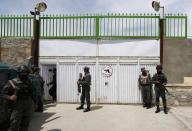 Afghan policemen stand at the gate of Cure Hospital after three Americans were killed in Kabul April 24, 2014. (REUTERS/Mohammad Ismail)