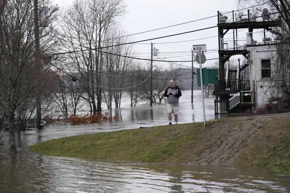 Drew Landry surveys the seen alongside the the flooded Kennebec River, Tuesday, Dec. 19, 2023, in Hallowell, Maine. Waters continue to rise following Monday's severe storm. (AP Photo/Robert F. Bukaty)