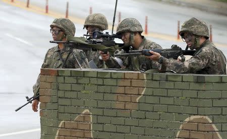 South Korean soldiers stand guard at a temporary checkpoint during a search for the South Korean conscript soldier who is on the run after a shooting incident, in Goseong June 22, 2014. REUTERS/Lee Jong-gun/Yonhap