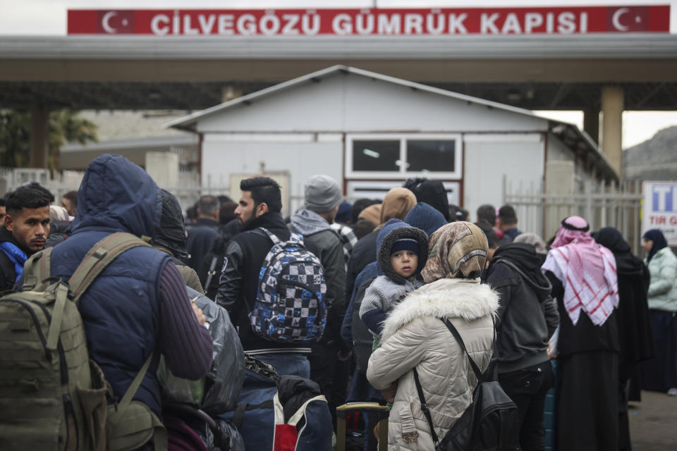 Syrians wait to cross into Syria from Turkey at the Cilvegozu border gate, near the town of Antakya, southeastern Turkey, Tuesday, Feb. 21, 2023. The death toll in Turkey and Syria rose to eight in a new and powerful earthquake that struck two weeks after a devastating temblor killed nearly 45,000 people, authorities and media said Tuesday. (AP Photo/Unal Cam)