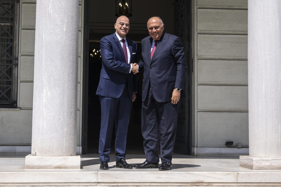 Greek Foreign Minister, Nikos Dendias, left, welcomes his Egyptian counterpart Sameh Shoukry , as they meet in Athens on Tuesday, April 11, 2023. Greece and Egypt have close military ties and are planning to build an undersea electricity grid connector across the Mediterranean. (AP Photo/Petros Giannakouris)