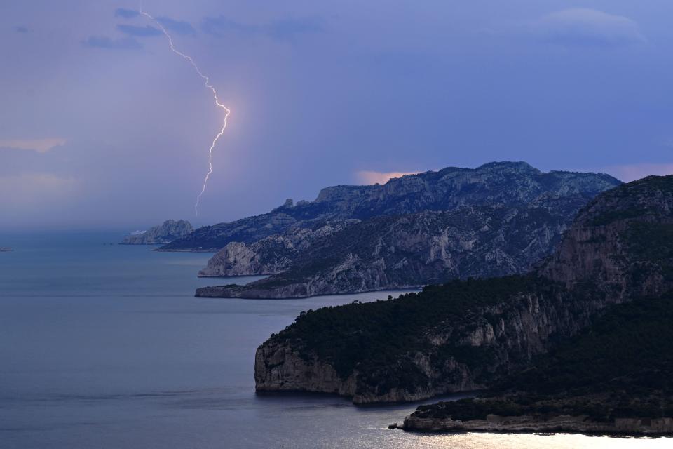 A lightning strikes over the Parc National des Calanques during a thunderstorm near Cassis, southern France, on June 14, 2023. (Photo by Nicolas TUCAT / AFP) (Photo by NICOLAS TUCAT/AFP via Getty Images)