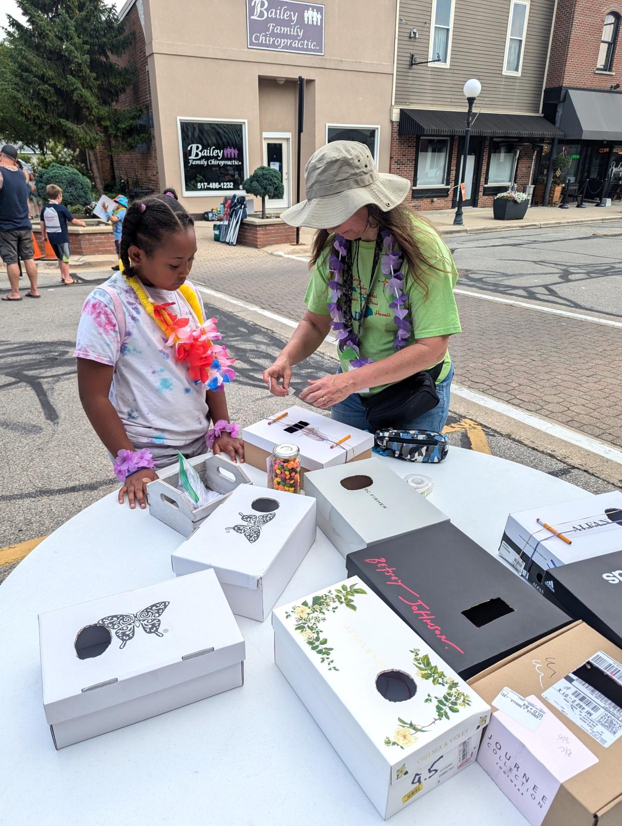 One of the aspects each month during the summer as part of Blissfield's Movies on Lane programming, is arts and crafts for kids. In June 2024, to kick off this year's Movies on Lane programs, Dixie Andres, right, helped people make shoebox banjoes.