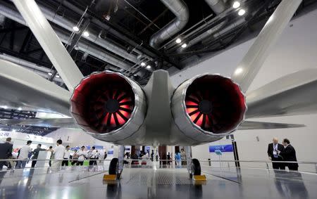 Foreign visitors stand next to a model of the J-31 stealth fighter at the Aviation Industry Corporation of China (AVIC) booth at the Aviation Expo China 2015 in Beijing, China, in this September 16, 2015 file photo. REUTERS/Jason Lee/Files