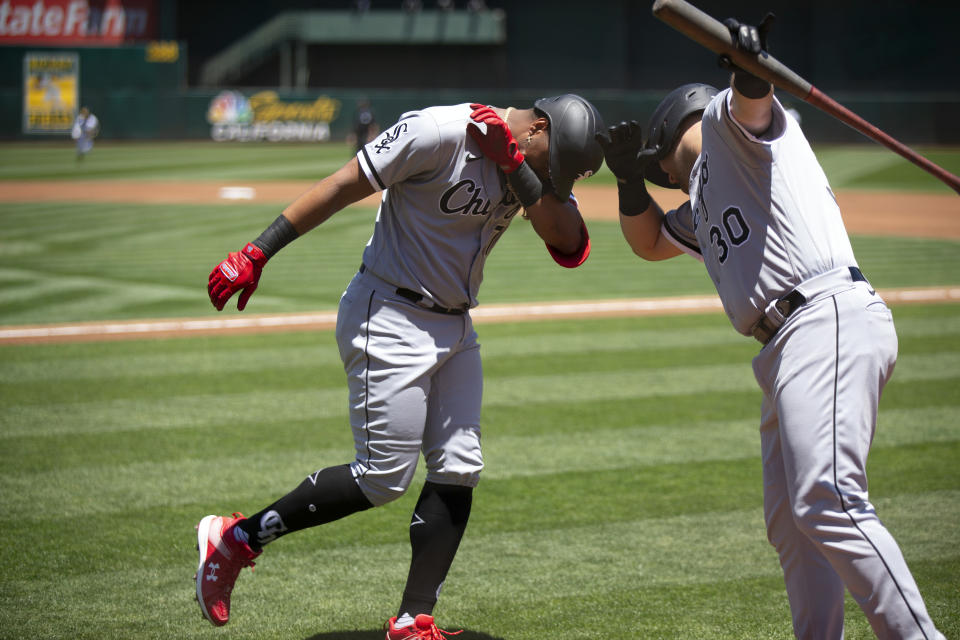 Chicago White Sox's Eloy Jiménez, left, celebrates after his solo home run with teammate Jake Burger (30) during the second inning of a baseball game against the Oakland Athletics, Saturday, July 1, 2023, in Oakland, Calif. (AP Photo/D. Ross Cameron)