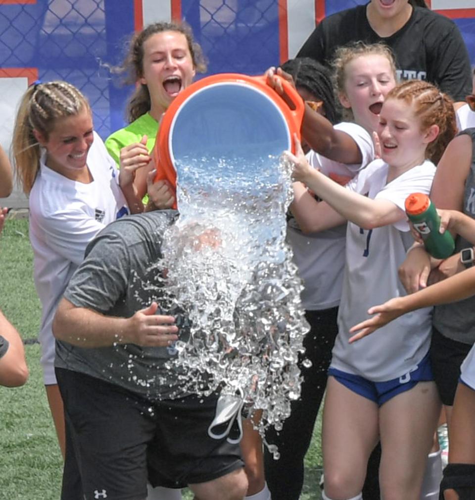 St Joseph's Head Coach Rick Morris is dunked with ice water by his players after beating Christ Church 2-0 at the Class AA 2022 SCHSL Girls Soccer State Championship game at Irmo High School Saturday, May 14, 2022.