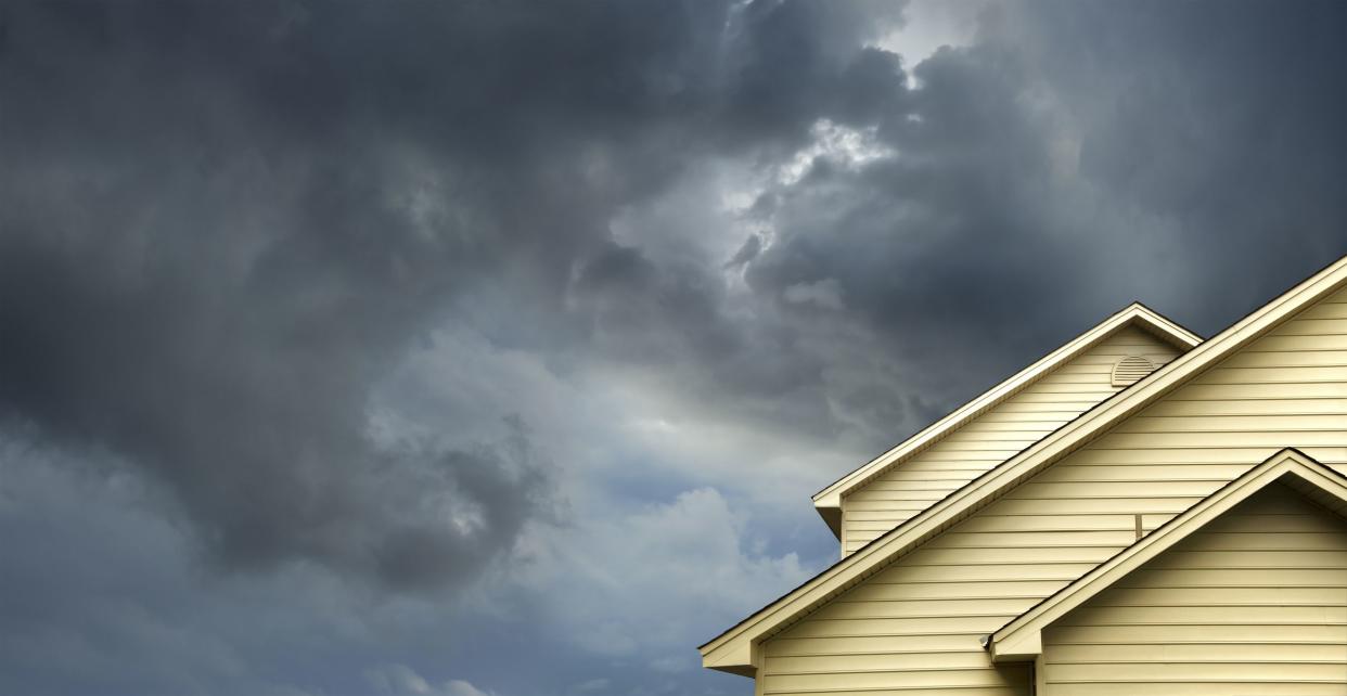 Close up of yellow house with storm clouds.