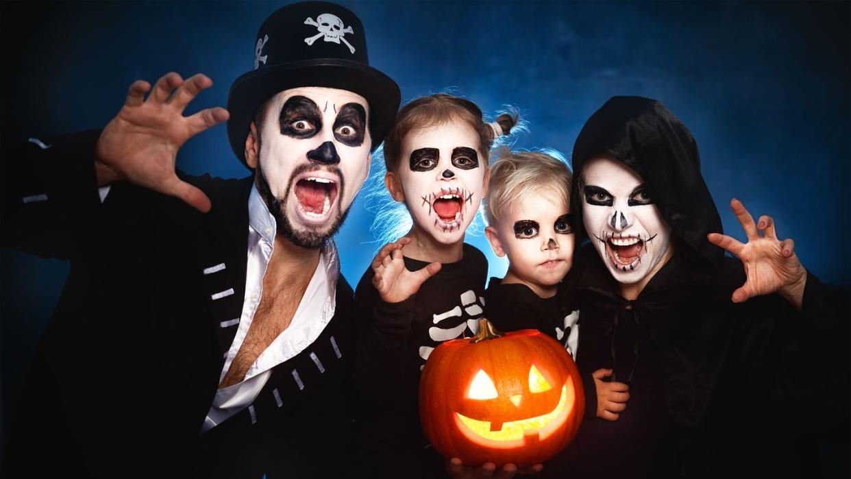 happy family mother father and children in costumes and makeup on halloween