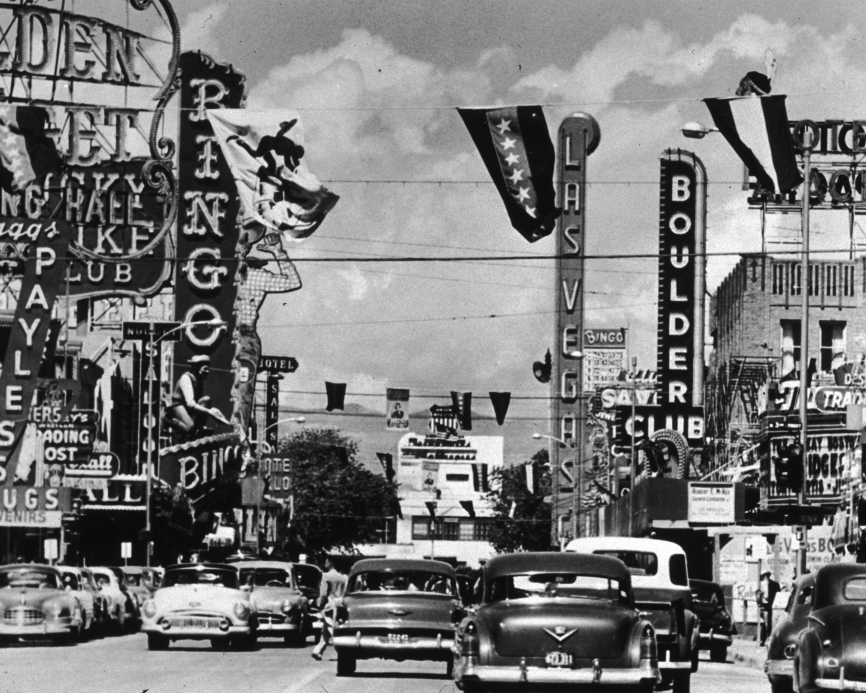 Cars driving past adverts and signs for clubs and casinos on Fremont Street in Las Vegas, Nevada.