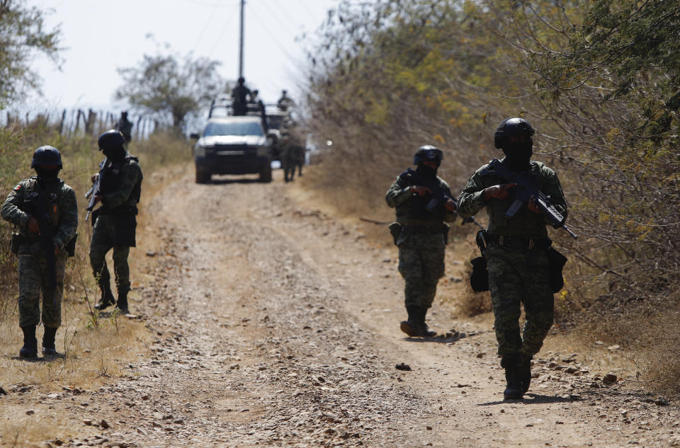 Members of the Mexican army patrol near Naranjo de Chila in the municipality of Aguililla, Mexico, Friday, Feb. 18, 2022. The town had been the scene of a bloody turf battle between two drug cartels. Earlier this month the government sent a large army contingent to free the zone from organized crime. (AP Photo/Armando Solis)