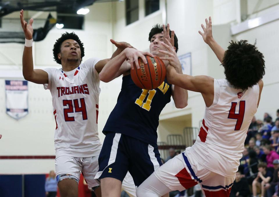 Xaverian Joe Fox is defended by Bridgewater-Raynham's DJ Overall and Deshawn Faulk during a game on Tuesday, Feb. 7, 2023.