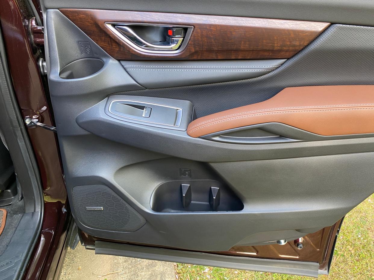 The Subaru Ascent Touring's back door features wood trim, tan leather accents, and 3 bottle holders.