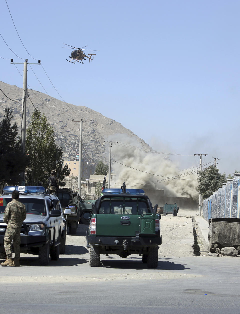 An MD 530F military helicopter targets a house where attackers are hiding in Kabul, Afghanistan, Tuesday, Aug. 21, 2018. The Taliban fired rockets toward the presidential palace in Kabul Tuesday as President Ashraf Ghani was giving his holiday message for the Muslim celebrations of Eid al-Adha, said police official Jan Agha. (AP Photo/Rahmat Gul)