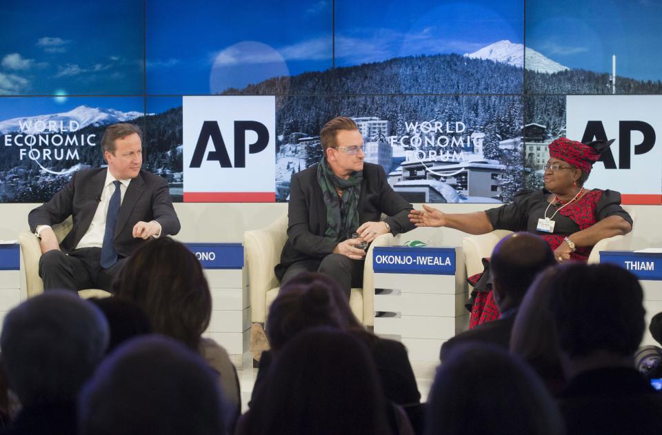 British Prime Minister David Cameron and rock star Bono, from left, listen to Nigerian Finance Minister Ngozi Okonjo-Iweala during a panel discussion "The Post-2015 Goals: Inspiring a New Generation to Act", the fifth annual Associated Press debate, at the World Economic Forum in Davos, Switzerland, Friday, Jan. 24, 2014. (AP Photo/Michel Euler)