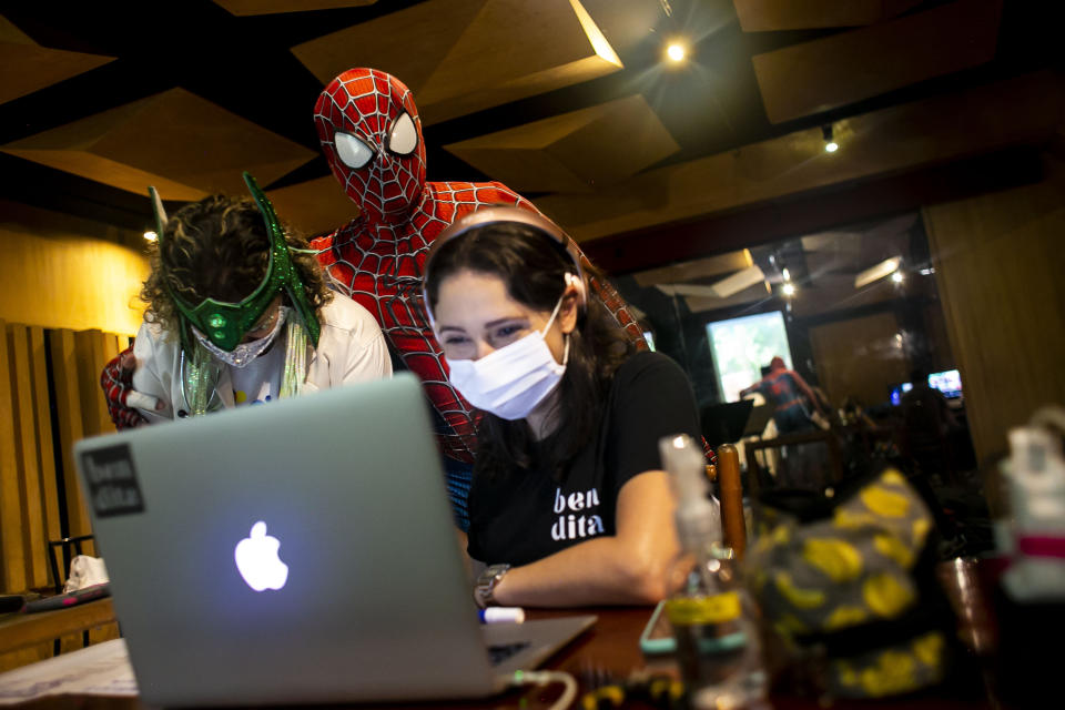 Members of the "Desliga da Justica" street band look at their production in Rio de Janeiro, Brazil, Sunday, Feb. 14, 2021. Their performance was broadcast live on social media for those who were unable to participate in the carnival due to COVID restrictions after the city's government officially suspended Carnival and banned street parades or clandestine parties. (AP Photo/Bruna Prado)