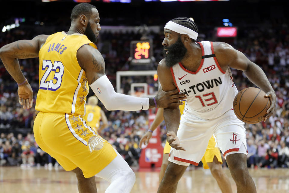 Los Angeles Lakers forward LeBron James (23) grabs Houston Rockets guard James Harden (13) after a rebound during the first half of an NBA basketball game Saturday, Jan. 18, 2020, in Houston. (AP Photo/Michael Wyke)