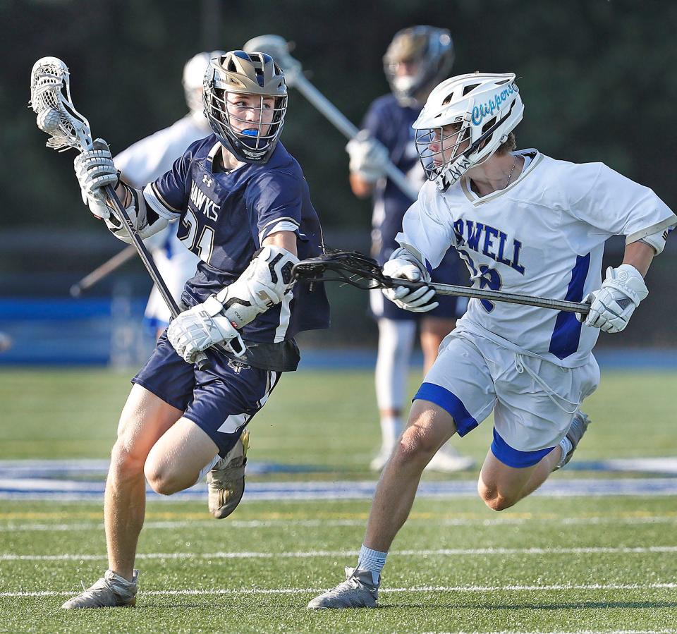 Hanover's Dylan Rice carries the ball against the defense of Norwell's Dylan McGuirk in the MIAA Division 3 semifinals on Friday, June 17, 2022.