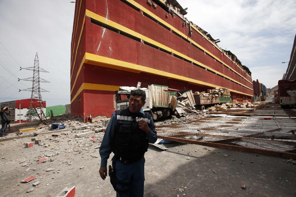 A security guard patrols the earthquake ravaged Duty Free Zone of Iquique, in Iquique, Chile, Friday, April 4, 2014. Following a magnitude-8.2 earthquake early in the week, soldiers have kept a close watch on supermarkets and gas stations to prevent looting as many people continued to line up on Friday for gasoline, water and food. The city remained largely peaceful and no new major damage or casualties were reported from the continuing aftershocks that have rattled the sleep-deprived citizens of Chile's north. (AP Photo/Luis Hidalgo)