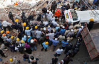 <p>Firefighters and rescue workers carry the body of a victim from the site of a collapsed building in Mumbai, India, Aug. 31, 2017. (Photo: Shailesh Andrade/Reuters) </p>