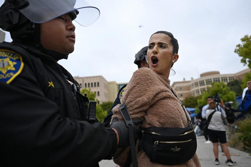 PHOTO: A pro-Palestinian demonstrator clash is arrested by police as an encampment is cleared after occupying and barricading the Physical Sciences Lecture Hall at the University of California, Irvine, in Irvine, Calif., on May 15, 2025.  (Patrick T. Fallon/AFP via Getty Images)