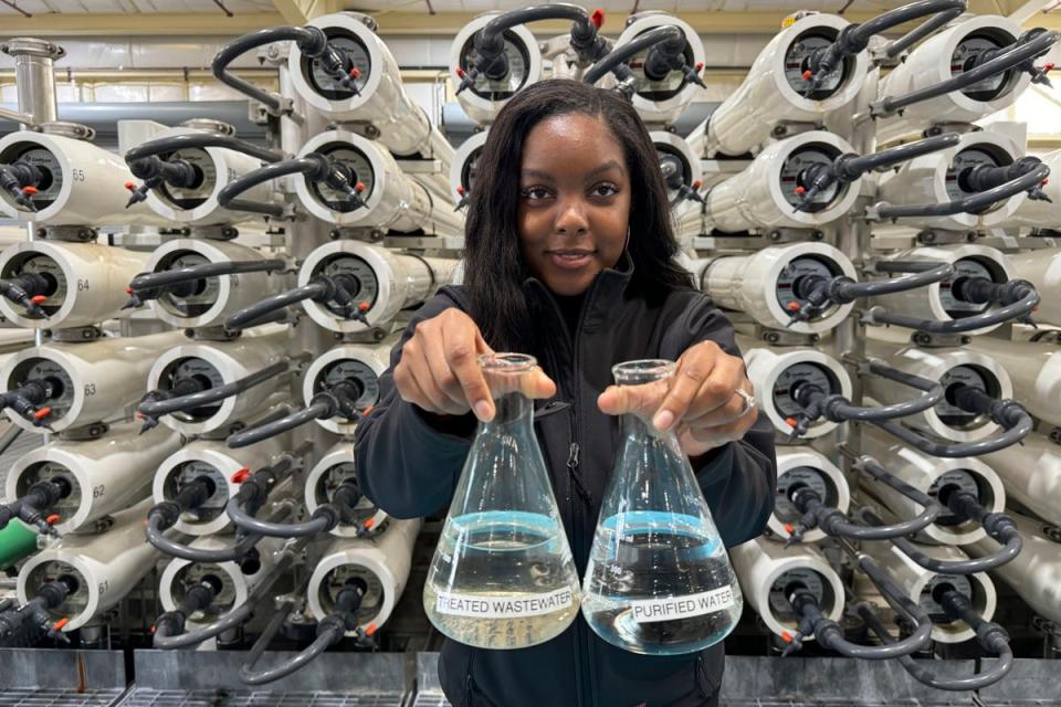 Lakeisha Bryant, public information representative at the Santa Clara Valley Water District, holds flasks of water before and after it is purified at the Silicon Valley Advance Purification Center, Wednesday, Dec. 13, 2023, in San Jose, Calif (AP)