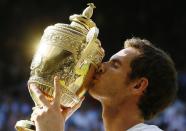 FILE - Andy Murray of Britain poses with the trophy after defeating Novak Djokovic of Serbia during the men's singles final match at the All England Lawn Tennis Championships in Wimbledon, London, in this Sunday, July 7, 2013, file photo. Murray ended a 77-year drought without a British man winning Wimbledon in 2013 and then won the tournament again in 2016. After two hip operations, he returns to the All England Club this year as a wild-card entry. Play begins Monday, Jujne 28, 2021 (AP Photo/Kirsty Wigglesworth)