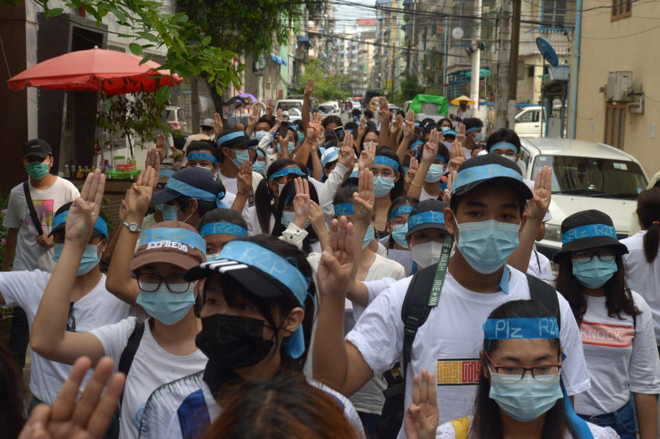 Anti-coup protesters flash the three-fingered salute while wearing headbands that read R2P, which means Responsibility to Protect, during a gathering in Ahlone township in Yangon, Myanmar Monday, April 12, 2021. The protesters have called for foreign intervention to aid them under the doctrine of Responsibility to Protect, or R2P, devised to deal with matters such as genocide, war crimes, ethnic cleansing and crimes against humanity. (AP Photo)