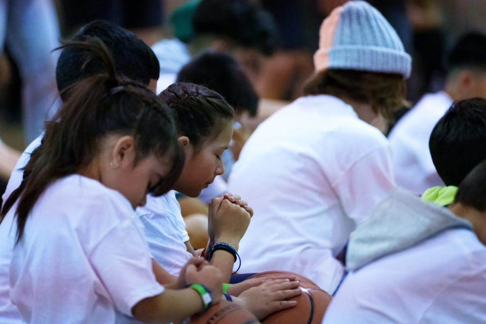 Campers bow their heads in prayers before the Prison Fellowship Angel Tree sports camp begins on March 25, 2023, in the Central Christian Church gym in Mesa.