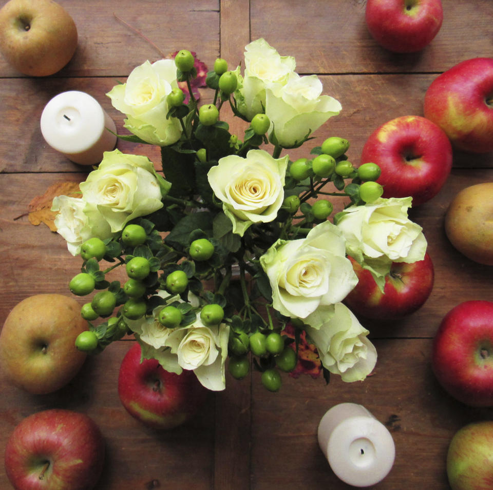 This November 2015 photo provided by Katie Workman shows flowers and apples on a table in New York. Setting up as much as possible ahead of time - such as flowers and little touches like fresh apples on a table— gives you a real leg up when it comes to getting the meal on the table Thanksgiving Day. (Laura Agra/Katie Workman via AP)